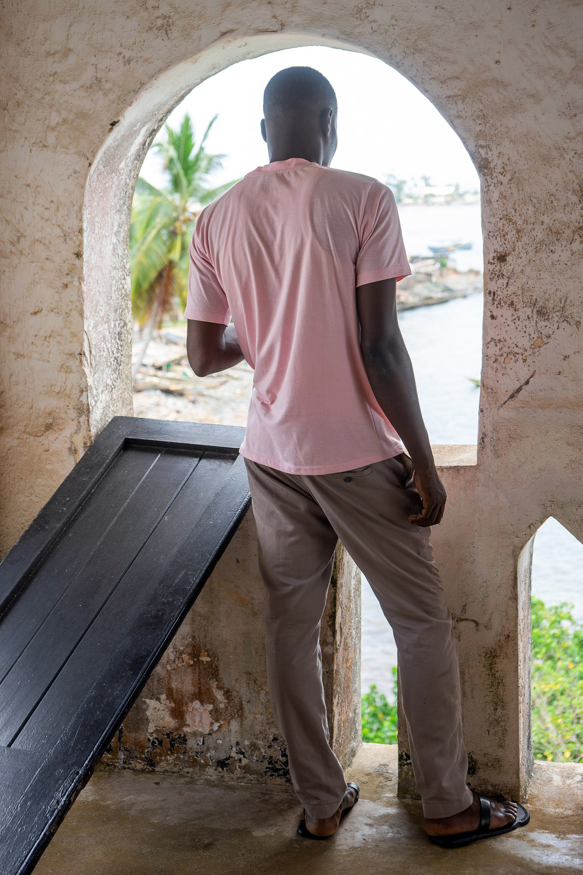 Man in Axim looks out of window